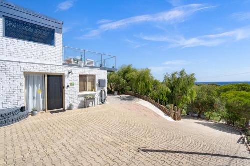 a brick house with a large driveway at Oceanview Manor by "Peppy Beach Retreats" - Two Houses in One with Panoramic Views in Capel