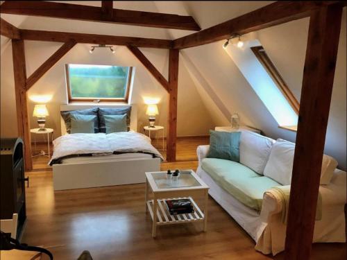ein Schlafzimmer mit einem Bett, einem Sofa und einem Tisch in der Unterkunft Hof Lillge in Schorfheide