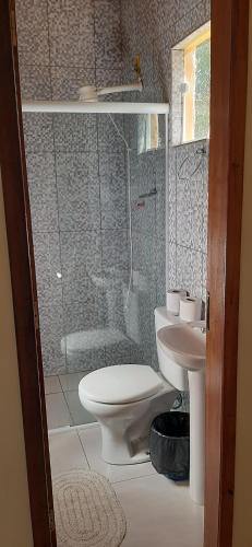 a bathroom with a shower and a toilet and a sink at Pousada Rural e Pesqueiro Chalé da serra in Conceição da Ibitipoca