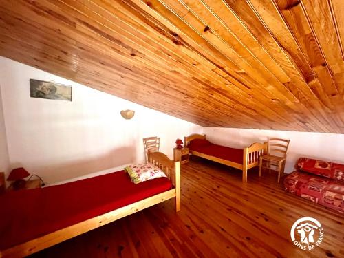 een slaapkamer met 2 bedden en een houten plafond bij Cabanat in Belvis