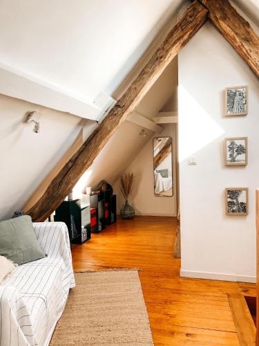 a living room with a white couch in a attic at Mas Parenthese - Chambres et Table d'Hôtes in Loze