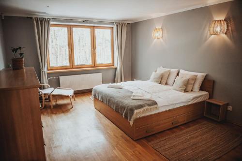 um pequeno quarto com uma cama e uma janela em Upės apartamentai I su terasa ir baseinu em Anykščiai