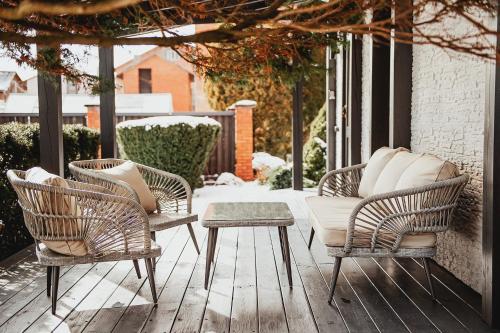 een groep stoelen en een tafel op een patio bij Upės apartamentai I su terasa ir baseinu in Anykščiai