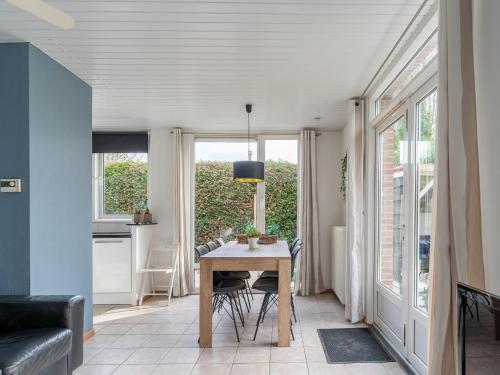a dining room with a table and some windows at Holiday Home in Zeeland near Lake in Baarland