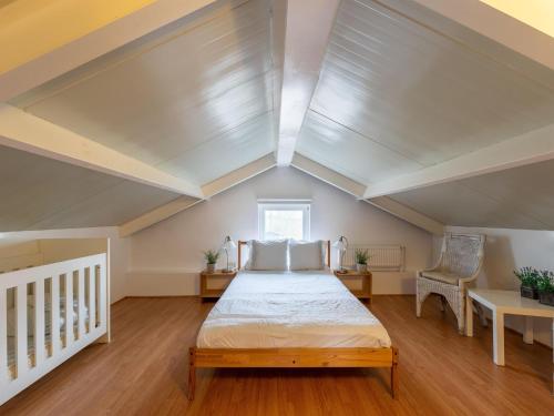 a large attic bedroom with a bed and a window at Welcoming holiday home in Baarland with fenced garden in Baarland