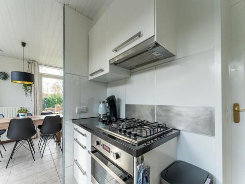 a kitchen with a stove top oven next to a table at Holiday Home in Zeeland near Lake in Baarland