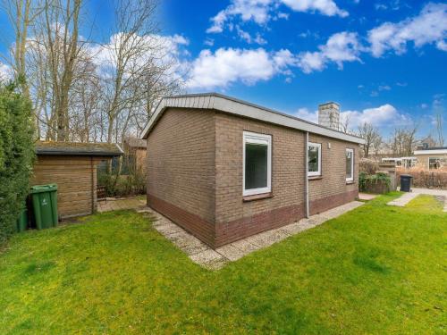 a small brick house in a yard at Holiday Home in Zeeland near Lake in Baarland