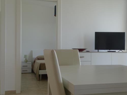 a living room with a white table and a television at Residence San Bull in Metaponto