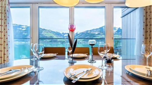 a dining room with a table and a large window at Alpin & See Resort - Pinzgau Holidays in Zell am See