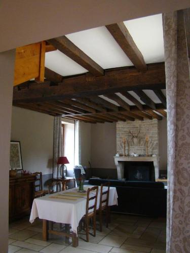 ein Wohnzimmer mit einem Tisch und einem Kamin in der Unterkunft La maison d'Agnes en Haute Bourgogne in Jully