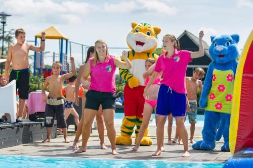 een groep kinderen in roze shirts die naast een zwembad staan bij Chalet (J10) op gezellige familiecamping bij zee in Kamperland