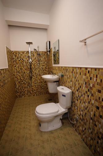 a bathroom with a toilet and a sink at River Inn in Matara