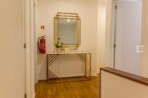 a dressing room with a mirror and a table with flowers at Pátio das Cantigas in Góis