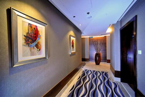 a living room with a painting on the wall at Ramada Abu Dhabi Corniche in Abu Dhabi