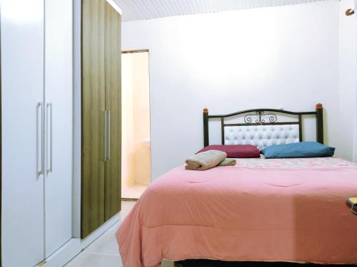 - une chambre avec un lit doté de draps et d'oreillers orange dans l'établissement Casa Excelente Localização Perto Furg,Praia!, à Rio Grande