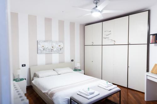 SWEET HOUSE CORSO GENOVA في ميلانو: غرفة نوم بسرير ابيض وجدران مخططة