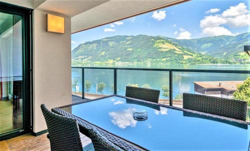 a dining room with a view of the water and mountains at Alpin & See Resort - Pinzgau Holidays in Zell am See