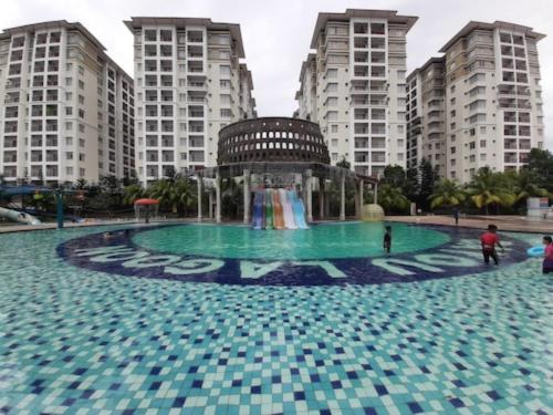 a fountain in the middle of a city with tall buildings at GWE Homestay in Bayou Lagoon Waterpark Resort Melaka in Malacca