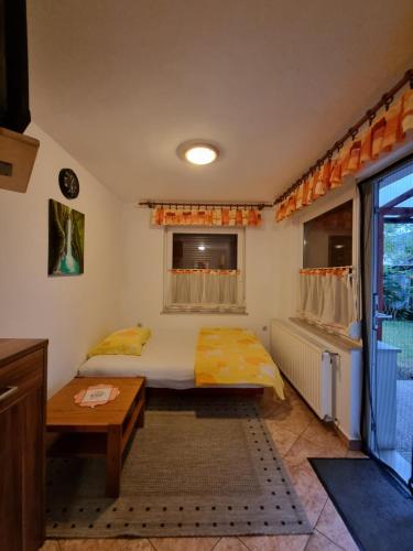 Schlafzimmer mit einem Bett, einem Tisch und einem Fenster in der Unterkunft Apartma Rutar in Tolmin