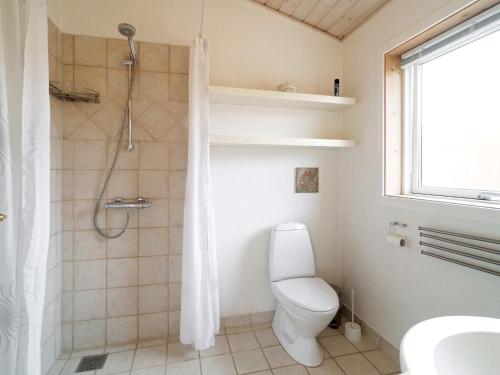 a bathroom with a white toilet and a shower at Two-Bedroom Holiday home in Stege 5 in Grevinge