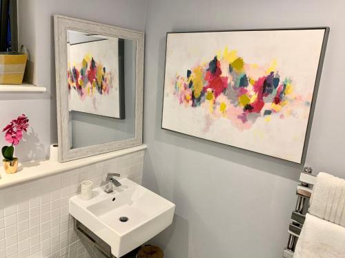 a bathroom with a sink and a mirror at Stylish Apartment Close to London Bridge in London