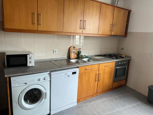 a kitchen with a washing machine and a sink at Casa da Luz in Angra do Heroísmo