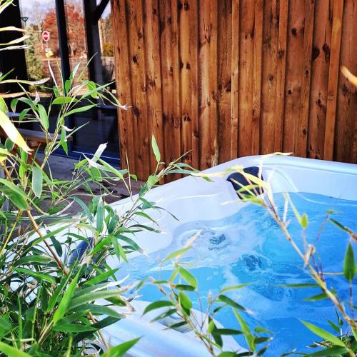 d'une baignoire installée à côté d'une clôture en bois. dans l'établissement Les Bord'Océanes Sauna & Spa Villa Marensine et Villa Oyat, à Vielle-Saint-Girons