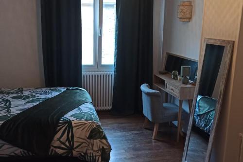 une chambre avec un lit, un bureau et une fenêtre dans l'établissement Petite maison de bourg proche A84, à Ducey