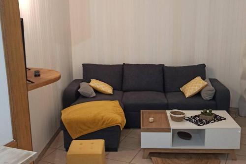 salon z niebieską kanapą i stołem w obiekcie Petite maison de bourg proche A84 w mieście Ducey