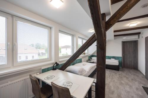 a room with two beds and a table and chairs at Penzion Rozhovice in Rozhovice