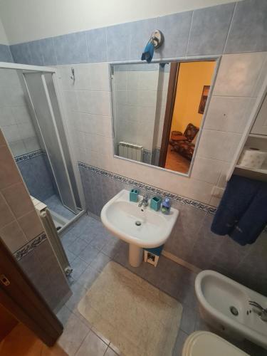 a bathroom with a sink and a toilet and a mirror at Case Vacanze Rocca in Bastia Umbra