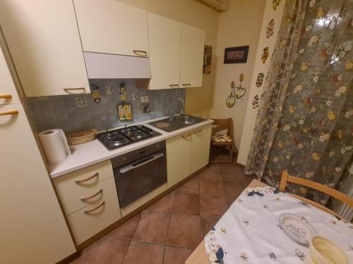 a kitchen with white cabinets and a stove top oven at Case Vacanze Rocca in Bastia Umbra