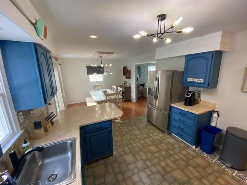 een keuken met blauwe kasten en een roestvrijstalen koelkast bij Stunning and Spacious 3br/2.5 ba only a block to the Bay Beaches in Wildwood Highlands Beach