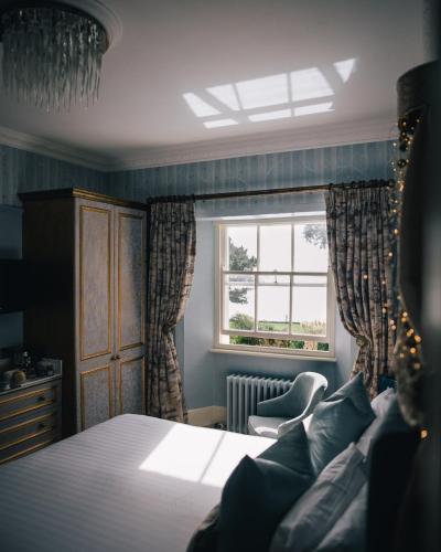 a bedroom with a bed and a window at Talland Bay Hotel, Looe in Talland