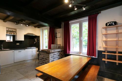 a kitchen with a wooden table in a room at Landgoed Karel van Yedeghem in Watou