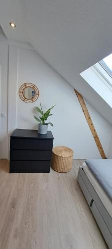 a bedroom with a plant on a black dresser at Waldstadt-Apartments in Iserlohn