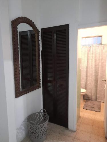 a bathroom with black doors and a mirror at Hermoso Apartamento frente Aeropuerto de Isla Verde in San Juan
