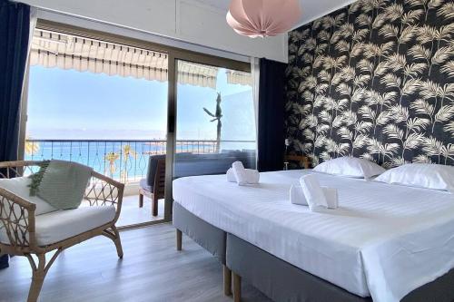 une chambre avec un lit, une chaise et une fenêtre dans l'établissement Le Garavan-vue mer-plage-clim-terrasse, à Menton