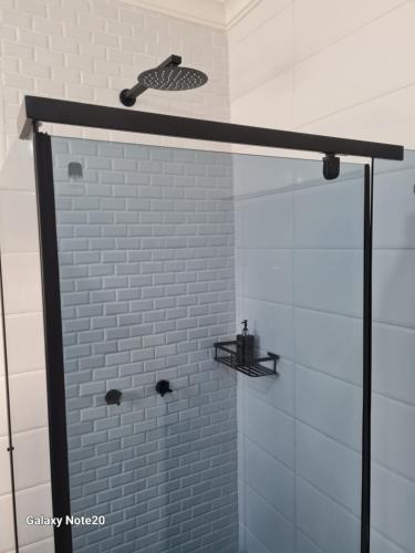 La salle de bains est pourvue d'une douche avec une porte en verre. dans l'établissement Egerton Overnight, à Kimberley