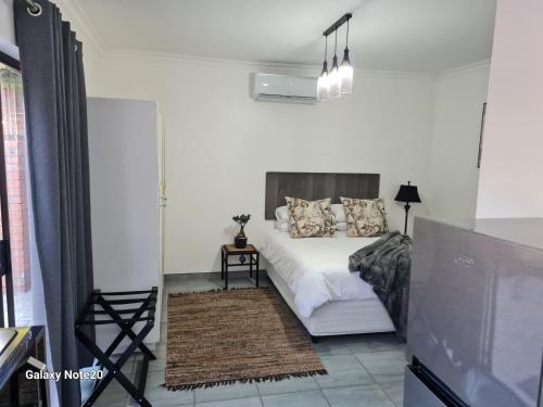 a bedroom with a white bed with pillows on it at Egerton Overnight & Stay in Kimberley