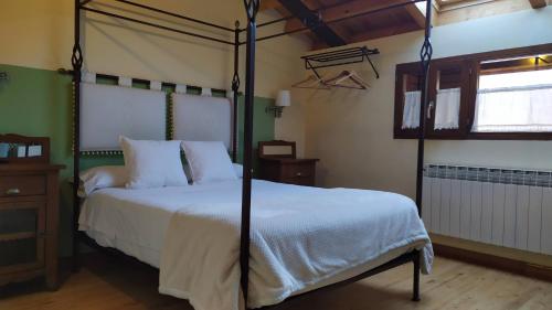 a bedroom with a bed with a four post canopy at Hotel Rural Cayetana in Piedrahita