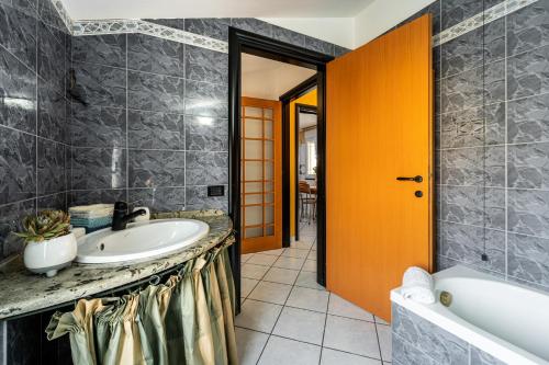 uma casa de banho com um lavatório e uma banheira em Casa Flu em Assemini