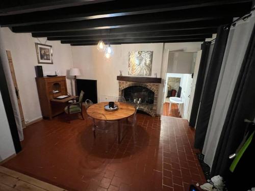 a living room with a table and a fireplace at Charmante maison berrichonne in Gargilesse-Dampierre