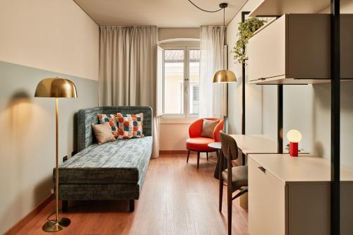 a living room with a couch and a chair and a table at URBANAUTS STUDIOS Minelli in Trieste