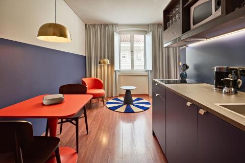 a kitchen with a red table and some chairs at URBANAUTS STUDIOS Minelli in Trieste