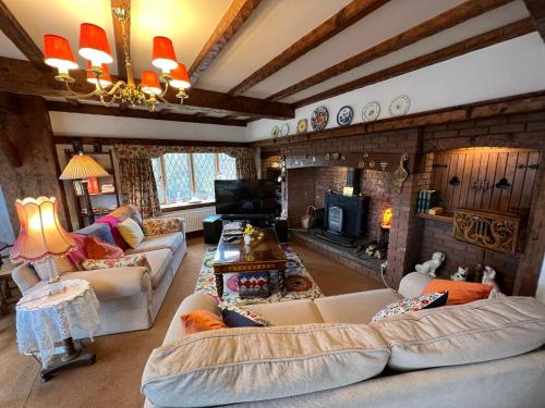 a living room with two couches and a fireplace at Pentre Cerrig Country House in Llanferres