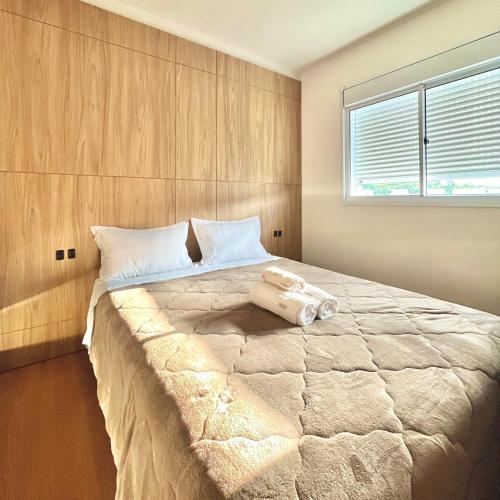 1 dormitorio con 1 cama grande y ventana en Apartamento Vert808, en Lajeado