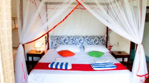a bedroom with a white bed with a canopy at FEEL Beach Villa in Kalutara