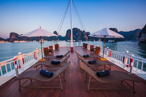 a boat with chairs and tables on the deck at Bhaya Halong Cruises in Ha Long
