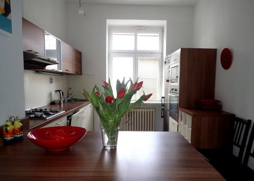 uma cozinha com um vaso de flores numa mesa de madeira em Superior apartment em Bratislava